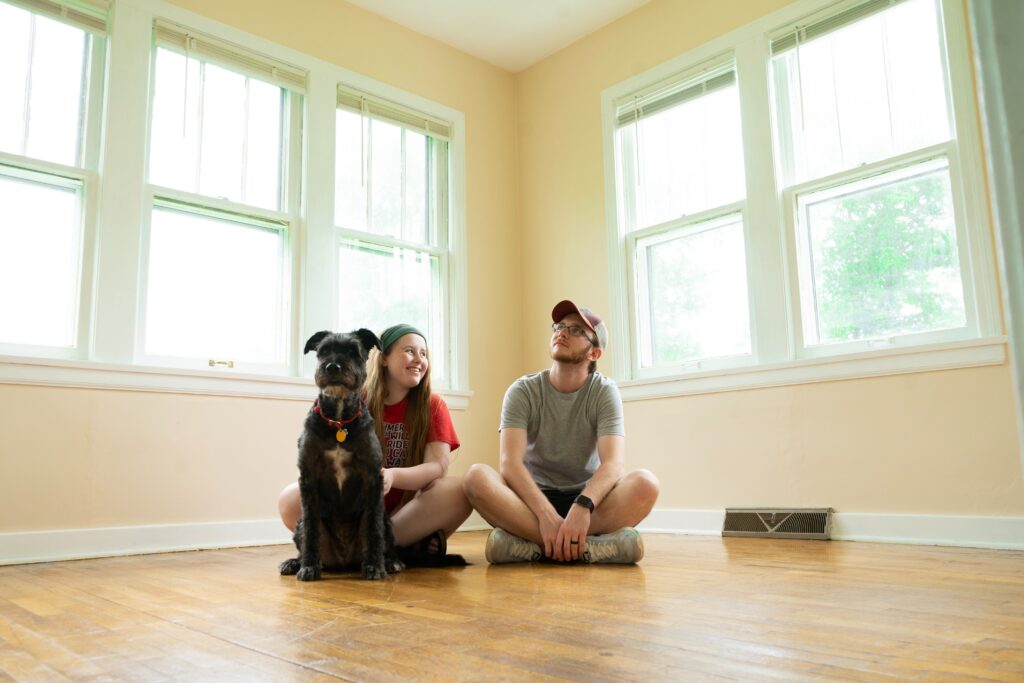 An image of a man, woman and a dog that moved into their new home.